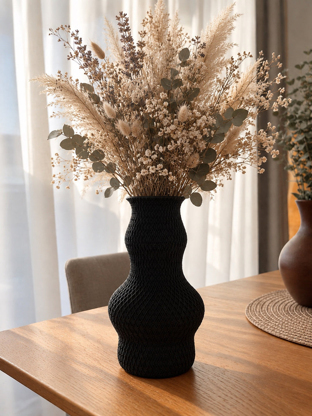 Schwarze Strukturvase Liora mit Trockenblumen auf einem Holztisch; Blumen nicht enthalten.